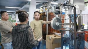 Mary présente la machine d'emballage de sachets en bâtonnets aux clients taïwanais