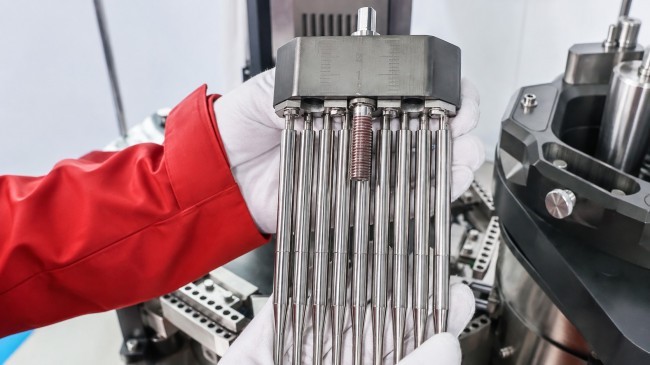 Technician replacing filling rods on an automatic capsule filling machine